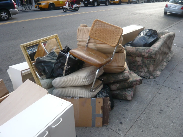 a pile of old furniture sitting on the side of a street