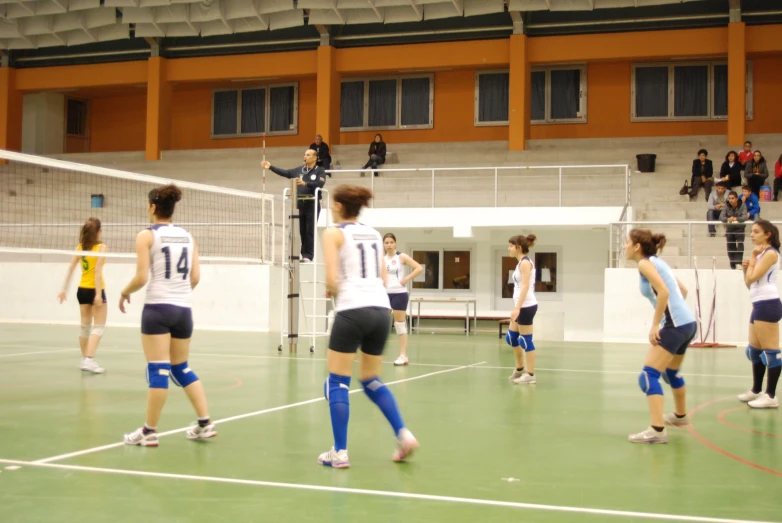 a group of girls are playing volleyball in a court
