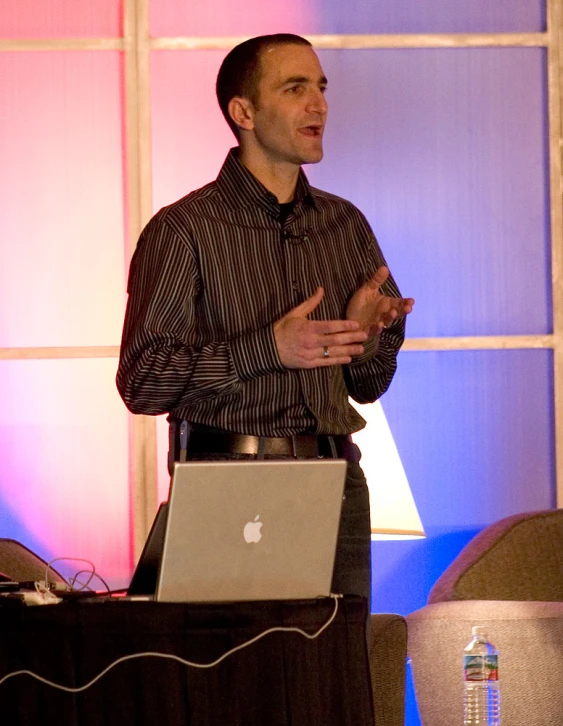 a man that is standing in front of a laptop