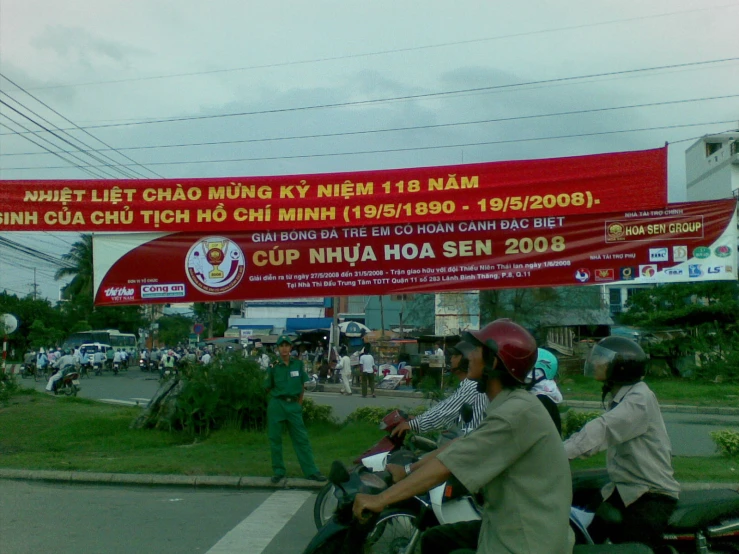 two people are riding motorcycles in front of a banner