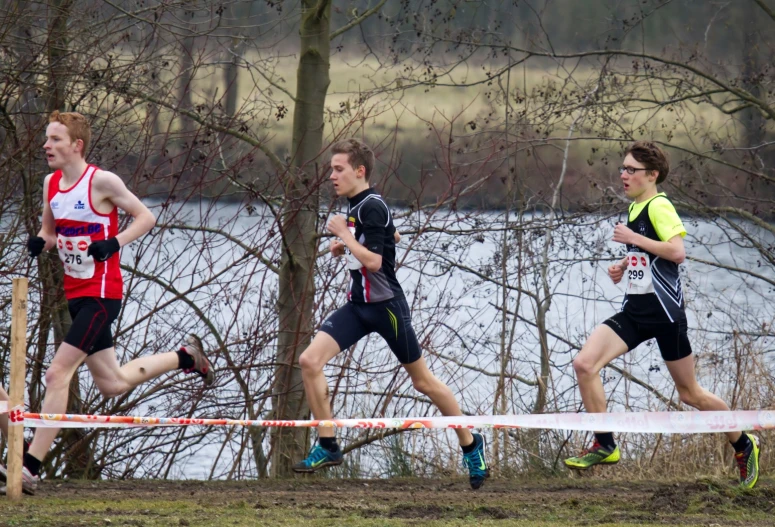 three men in the running race racing along a path