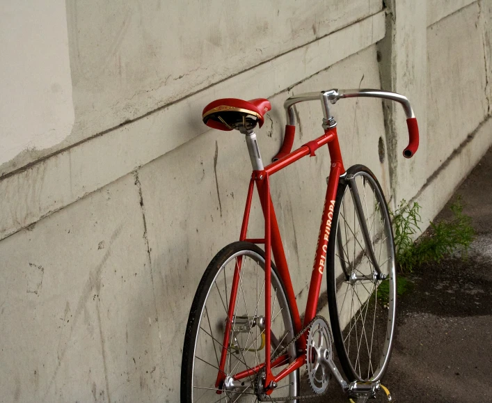 a bike parked against the side of a wall with its seat and back