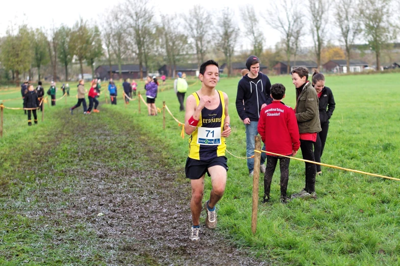 a group of people race through a grass covered field