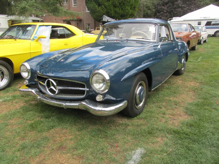 antique cars are parked in a field at a car show