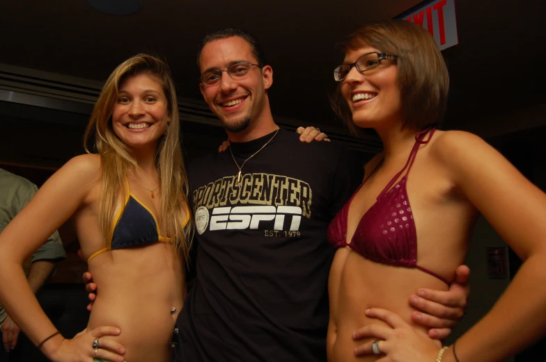 three attractive young women in bathing suits posing for a po