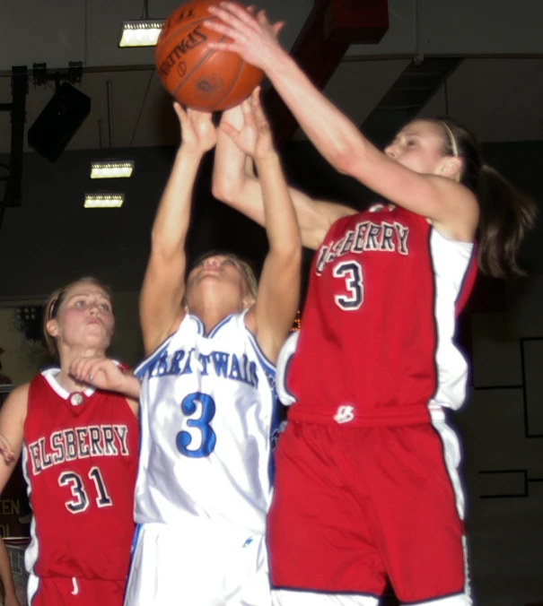 the girls are playing basketball against each other