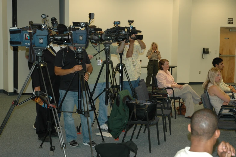 a cameraman filming some people at a public event