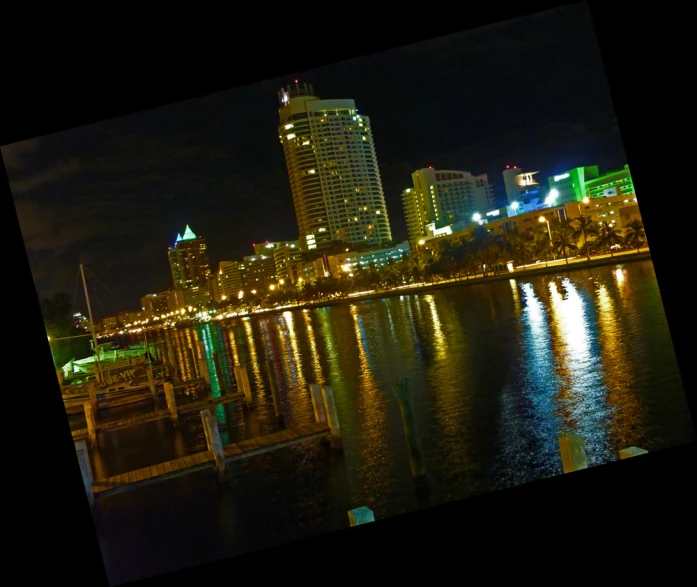 the skyline is lit up at night with many lights reflecting in the water