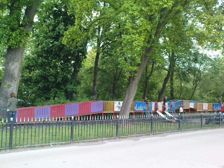 a colorful train at a park in the daytime