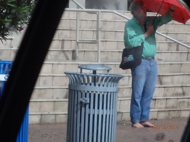 a man standing in front of a fence holding an umbrella