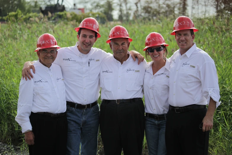 four people posing for a picture with hard hats on