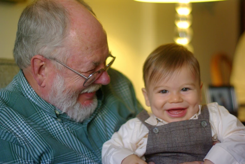 an older man holding a  smiling