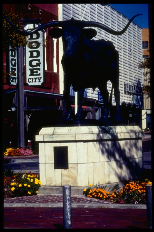 a black statue of a bull in the center of the city