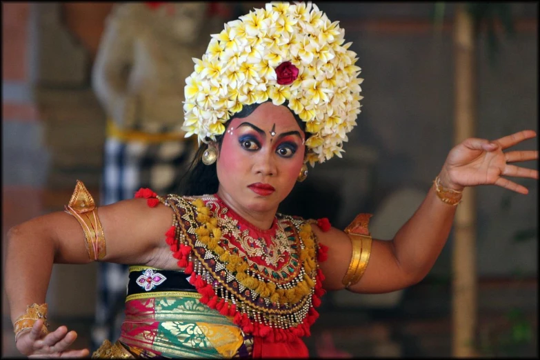 a young woman dressed in traditional thai costumes with flowers and hair