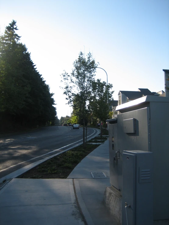 a small box sits on the sidewalk in front of a sidewalk light