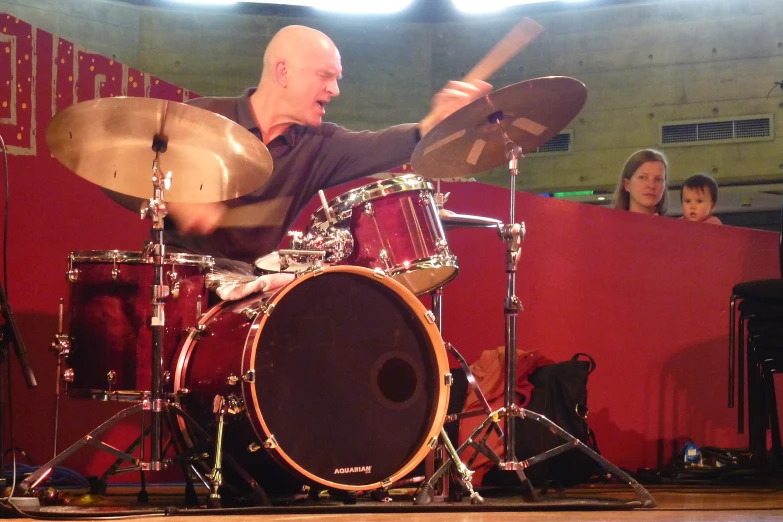 a man with an instrument stands on the side of a stage