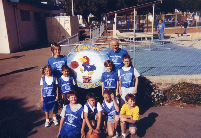 a group of s standing in front of a sign