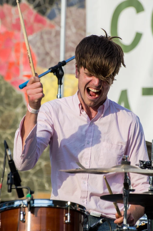 a man holding a drum and holding it up to his right