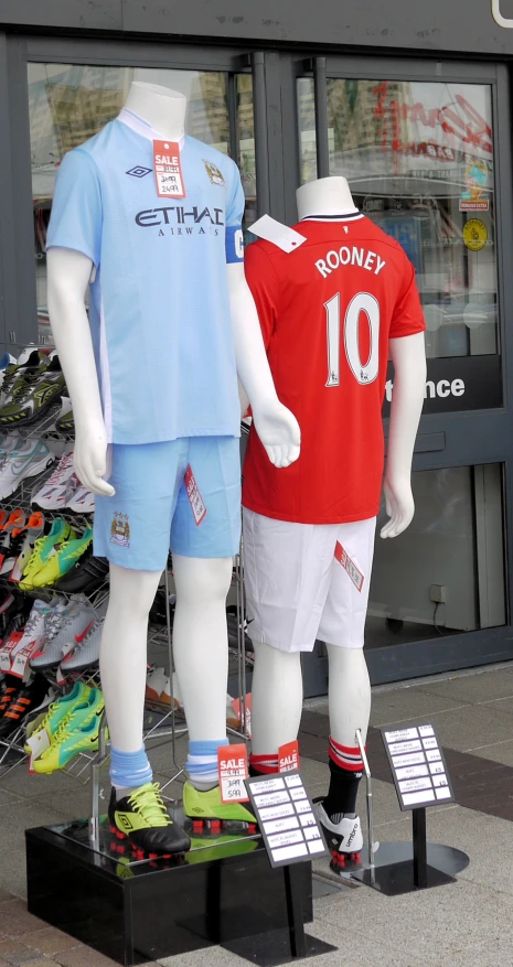 two soccer uniforms sit on display in front of the store