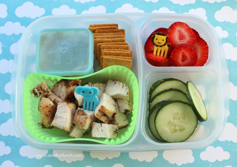 a plastic container has food in it and sits on a blue table