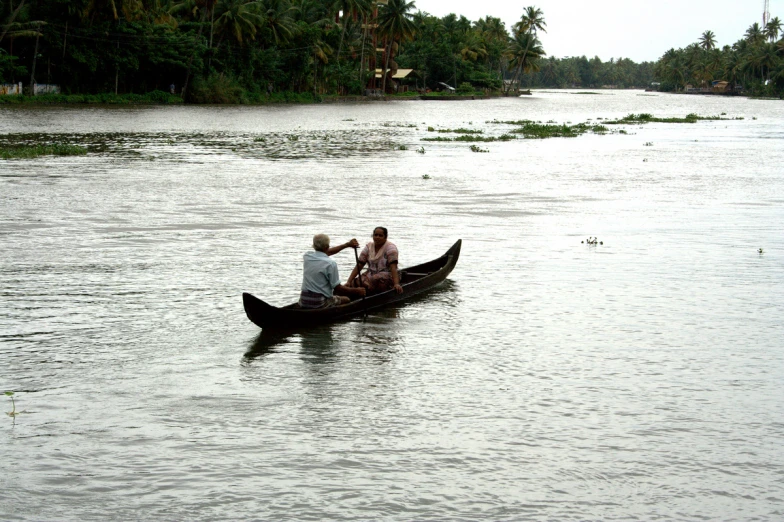 two people are riding a boat in the middle of water