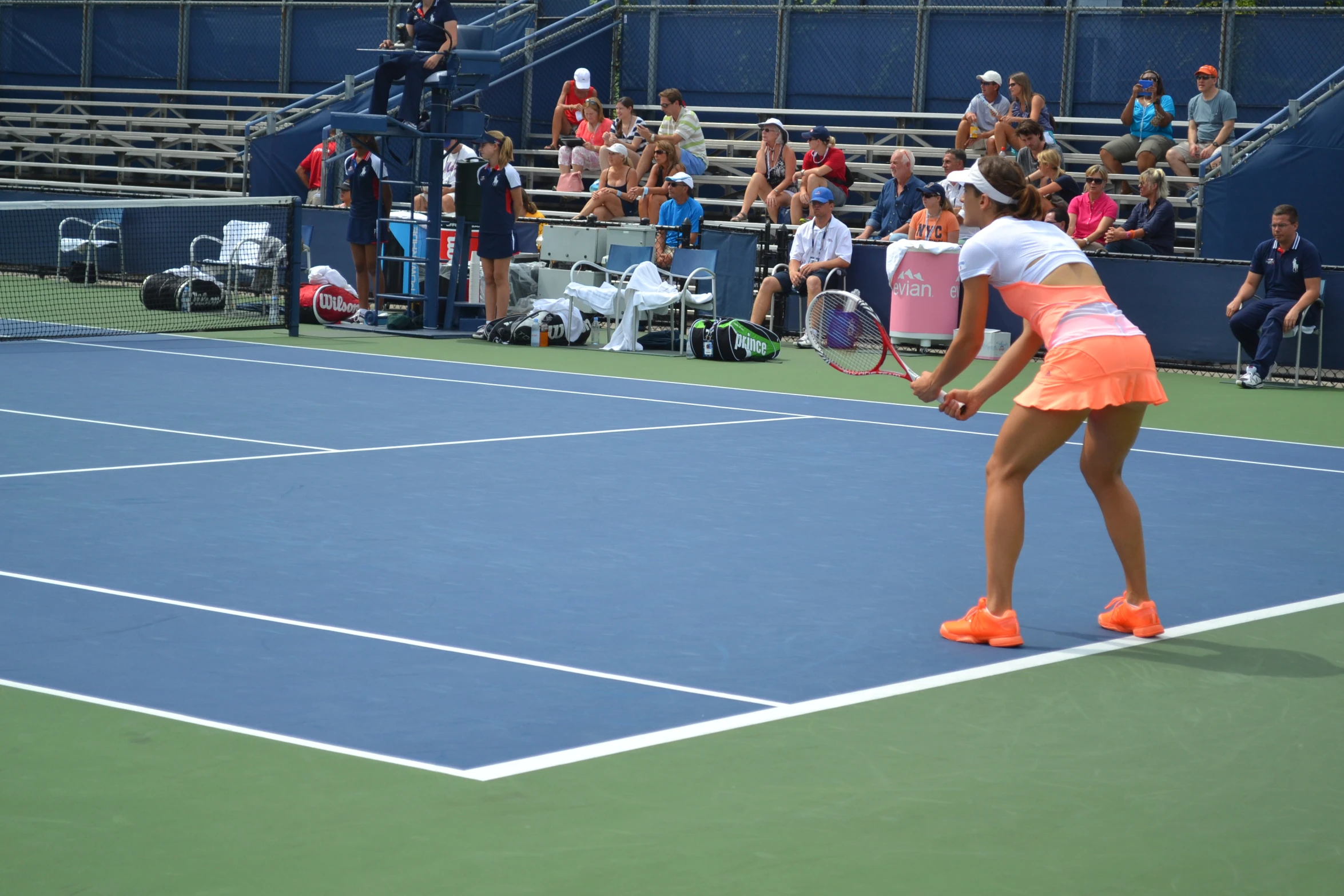 a woman playing tennis while some people watch