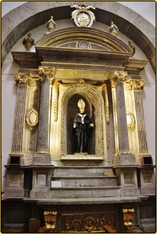 the statue is set inside of a golden altar