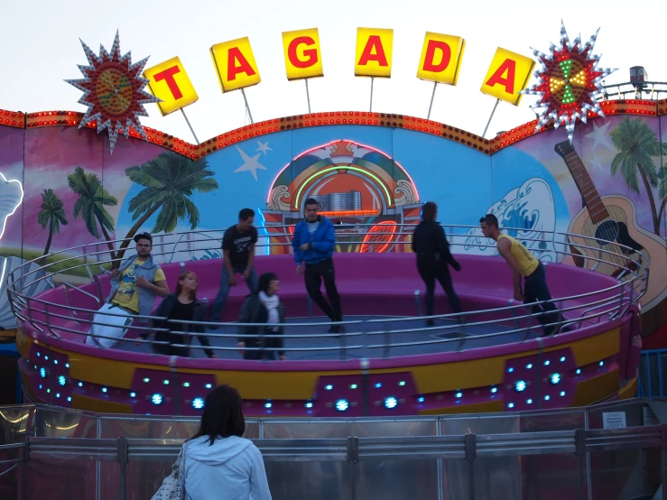 there are people standing in front of a ride