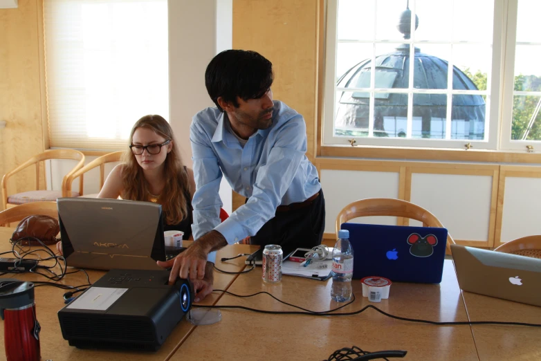 two people working on laptop computers next to each other