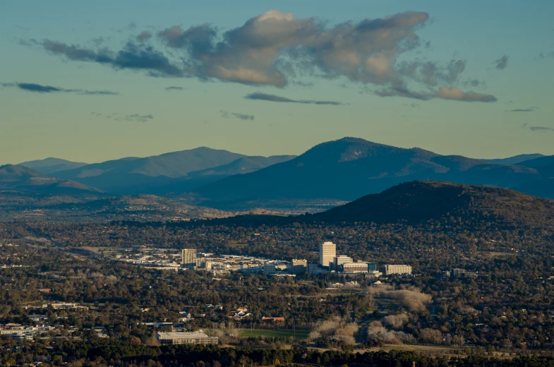 view from a very tall hill overlooking the city and mountains