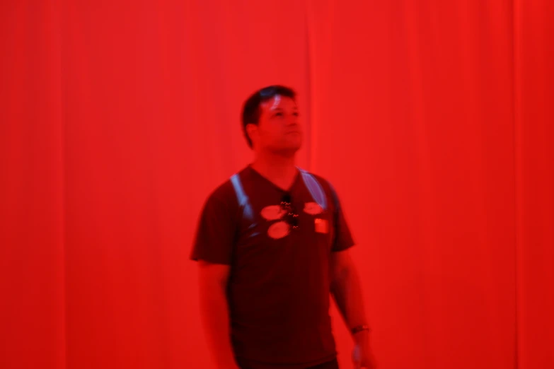 a man is standing in front of red curtains