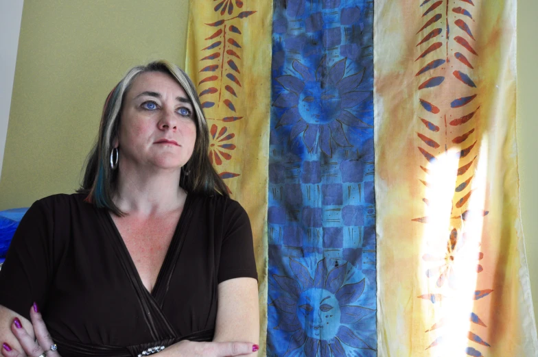 a woman with blue hair is sitting in front of a window