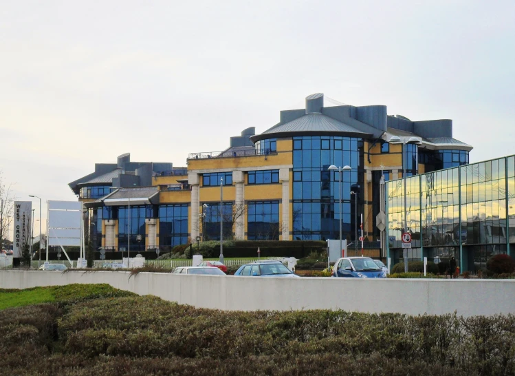 a city building with cars parked by the building