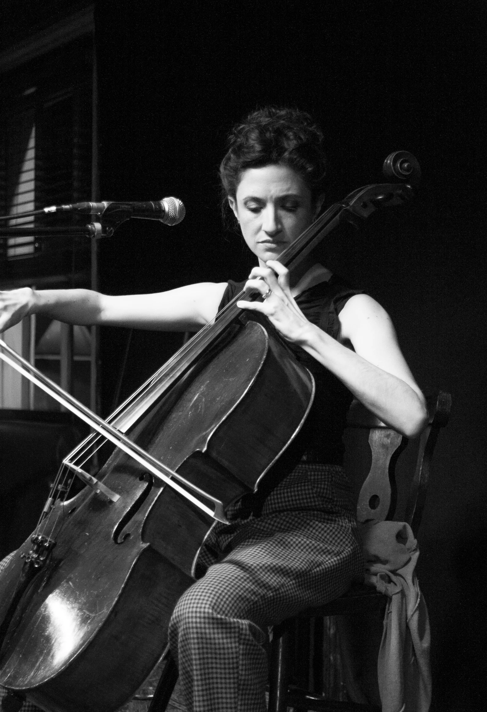 a man plays a cello while sitting in a chair