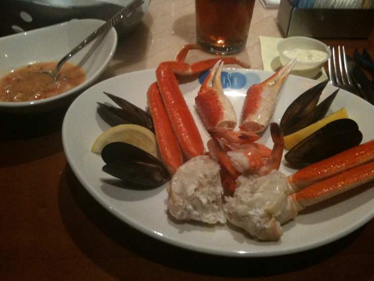 shrimp claws, prawls, and crab feet are on a white plate with orange and yellow garnishes