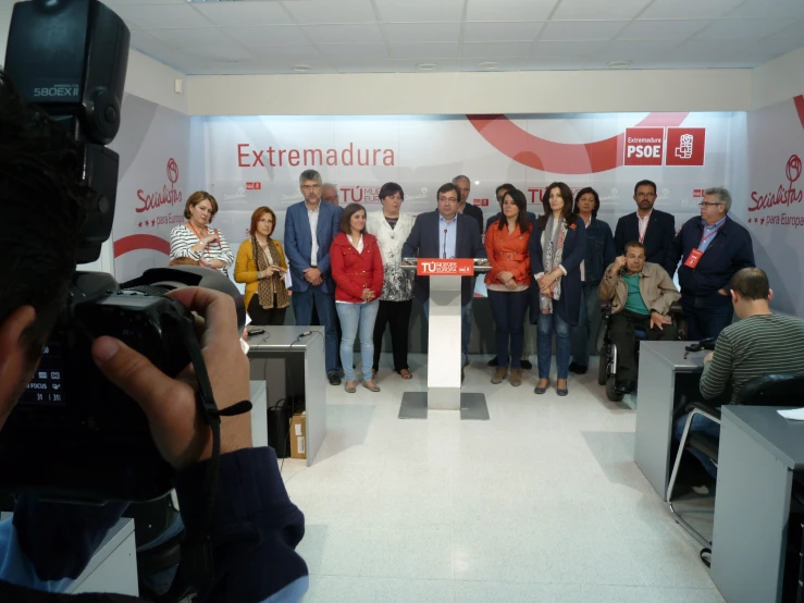 a group of people in front of a microphone with cameras around them