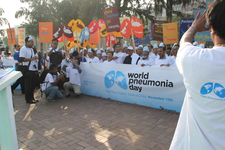 a group of people sitting behind a banner in a park