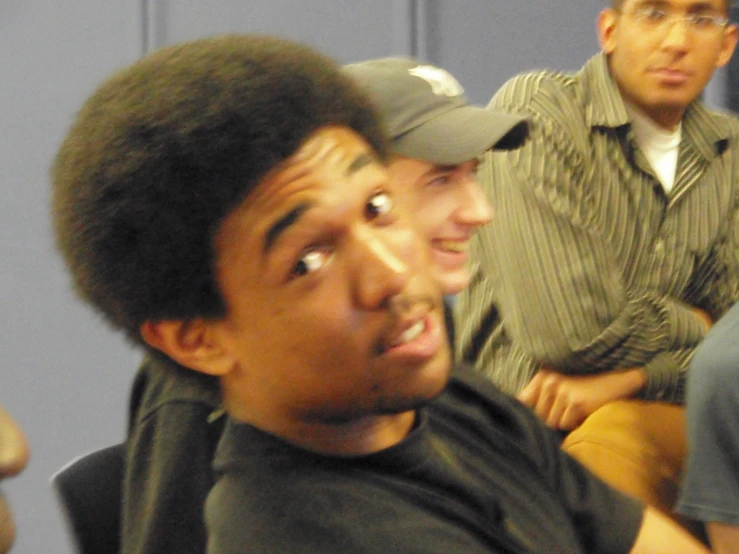 three men look directly up at soing while they are sitting together