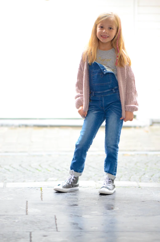 a  in overalls smiling at the camera