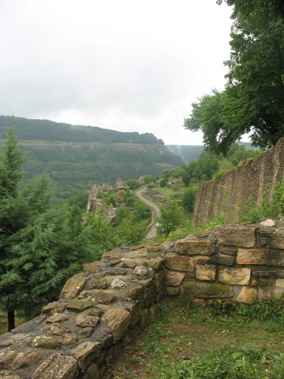 an area with green bushes and tall hills