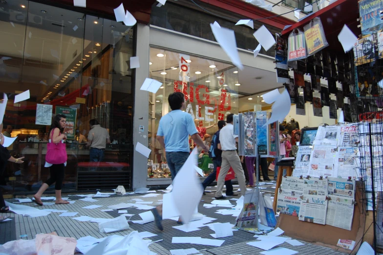 many people are outside with paper on the floor