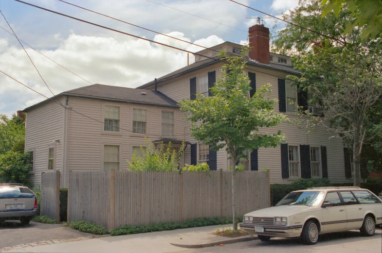 an old brick and vinyl house next to a wooden fence