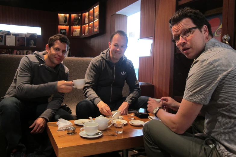 four men at a table having lunch and coffee