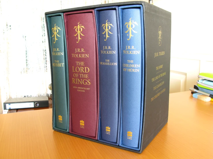 a row of three colored law books on a wooden table