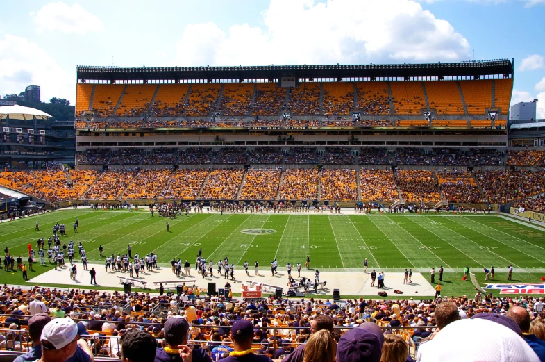 a large group of people standing on top of a football field