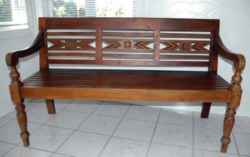 a wooden bench sitting in a bathroom under the window