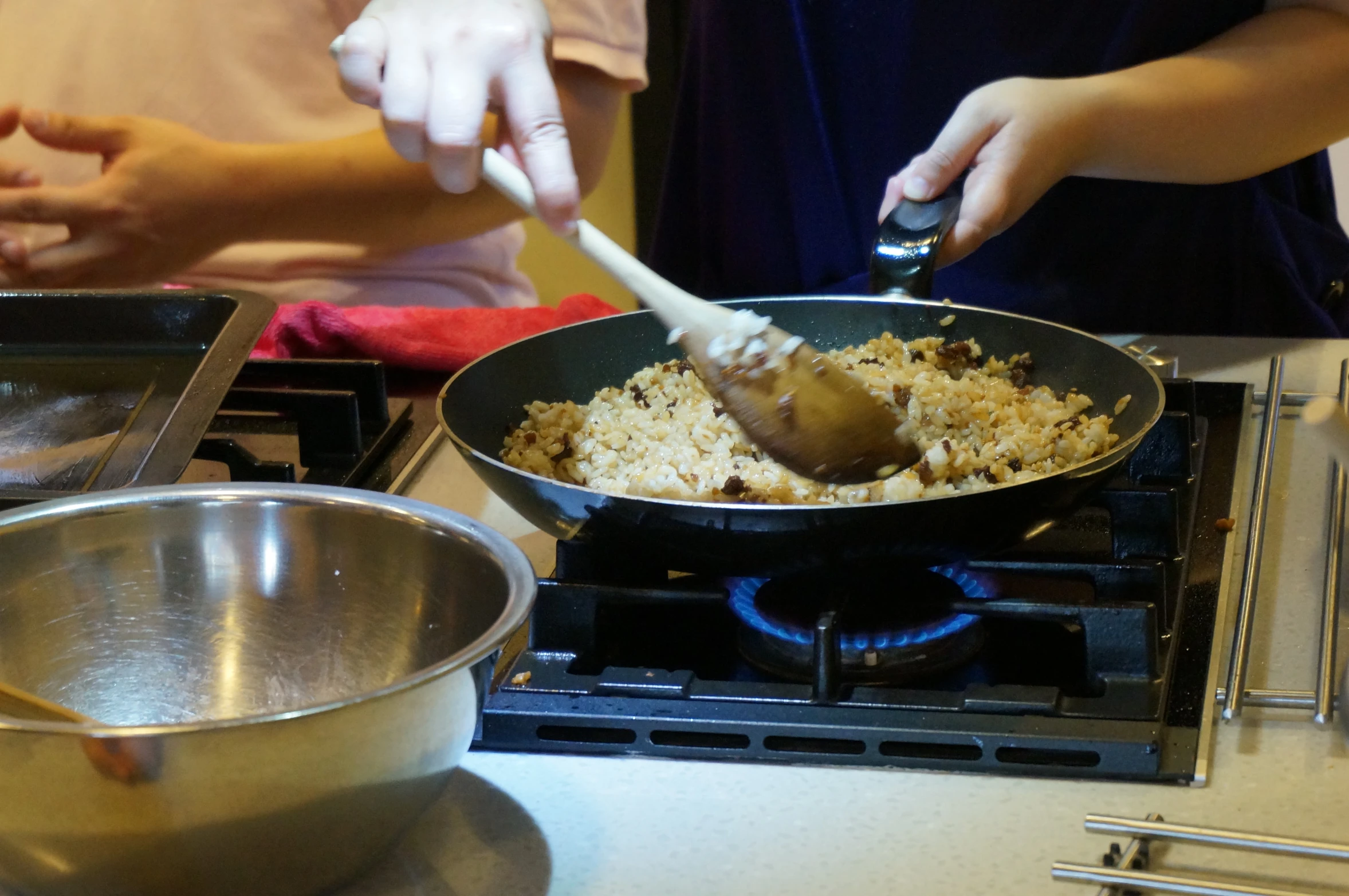 two people frying food on the stove in an asian style set