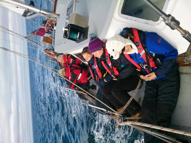 three people on a sailboat in the open water