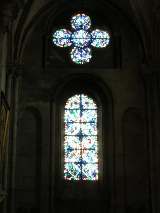 large colorful stained glass window with cross over it