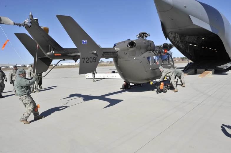 a couple of soldiers loading soing onto the side of an airplane